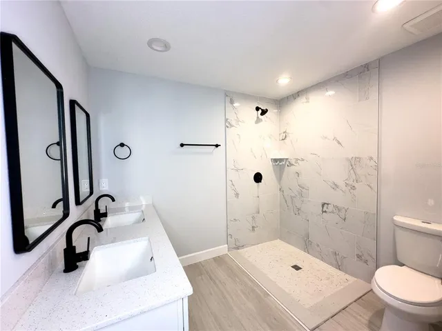 a bathroom with a sink a toilet and shower