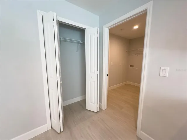 an empty room with wooden floor and entrance