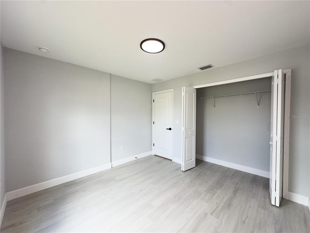 3602 Gillot Boulevard Port Charlotte, FL 33981 - Photo 25 of 28 an empty room with wooden floor and windows