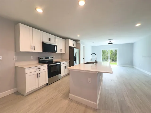 a kitchen with a sink cabinets and wooden floor