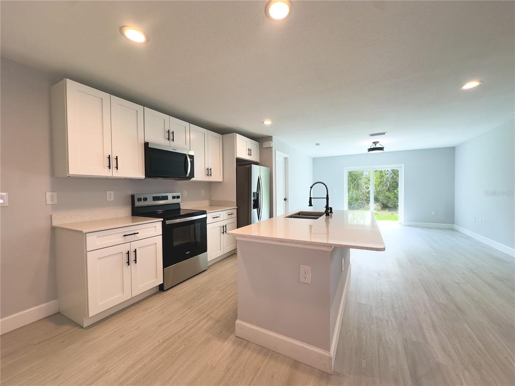 3602 Gillot Boulevard Port Charlotte, FL 33981 - Photo 10 of 28 a kitchen with a sink cabinets and wooden floor