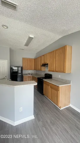 a large kitchen with cabinets and wooden floor