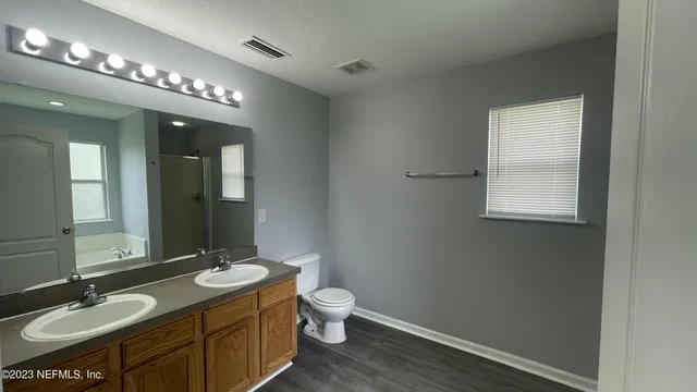 a bathroom with a granite countertop sink a toilet and a mirror