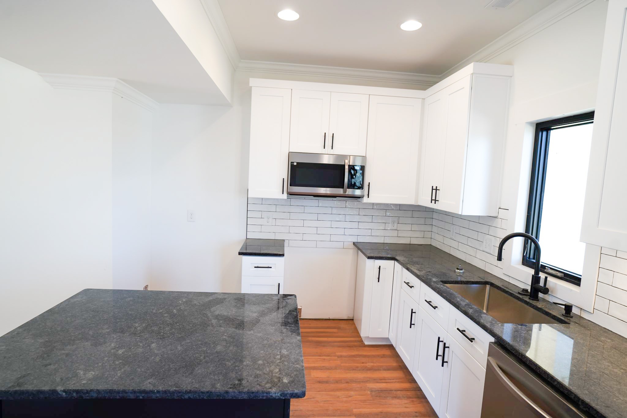 943 Overlook Trail Stewart, TN 37175 - Photo 14 of 35 a kitchen with granite countertop a sink and a stove top oven with wooden floor