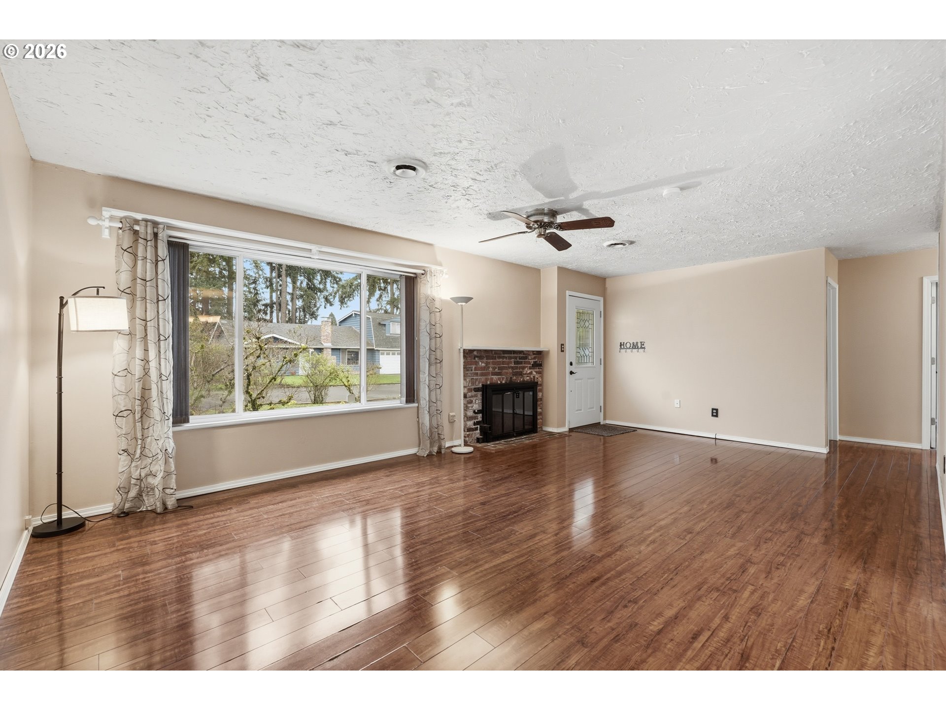 335 Southwest 141st Avenue Beaverton, OR 97006 - Photo 5 of 42 a view of empty room with wooden floor and fireplace