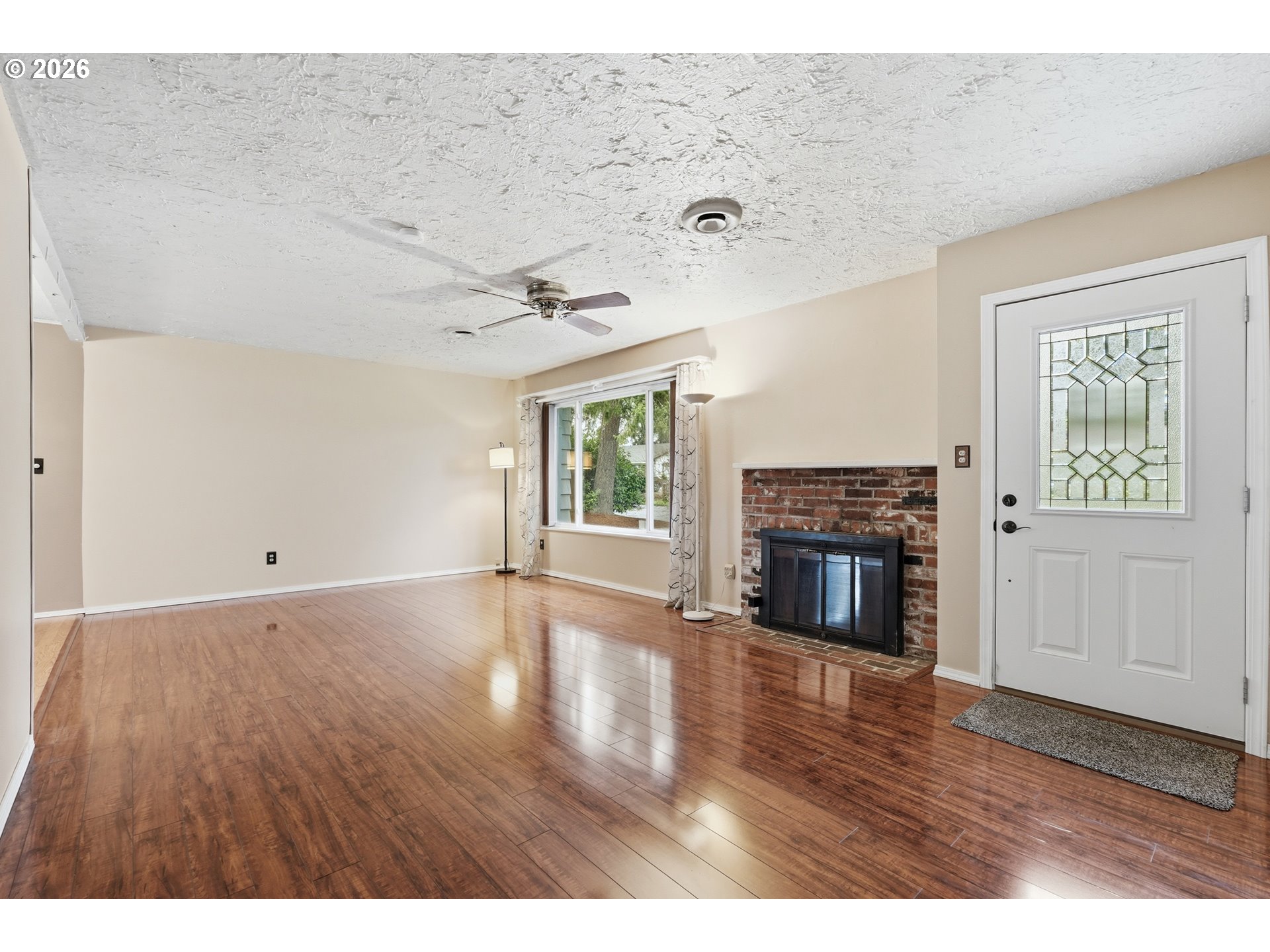 335 Southwest 141st Avenue Beaverton, OR 97006 - Photo 7 of 42 a view of empty room with wooden floor and fireplace