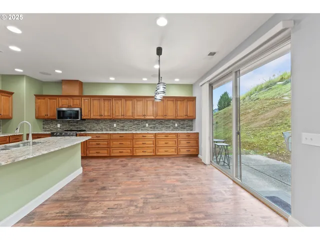 a large kitchen with kitchen island granite countertop a large window