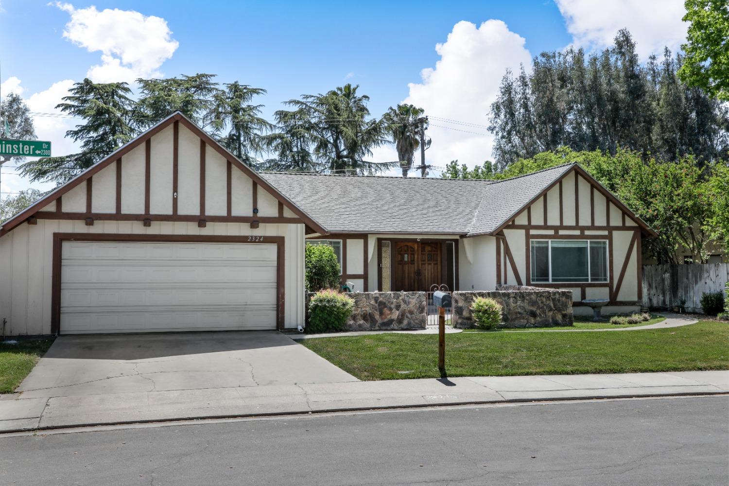 a view of a white house with a yard and plants
