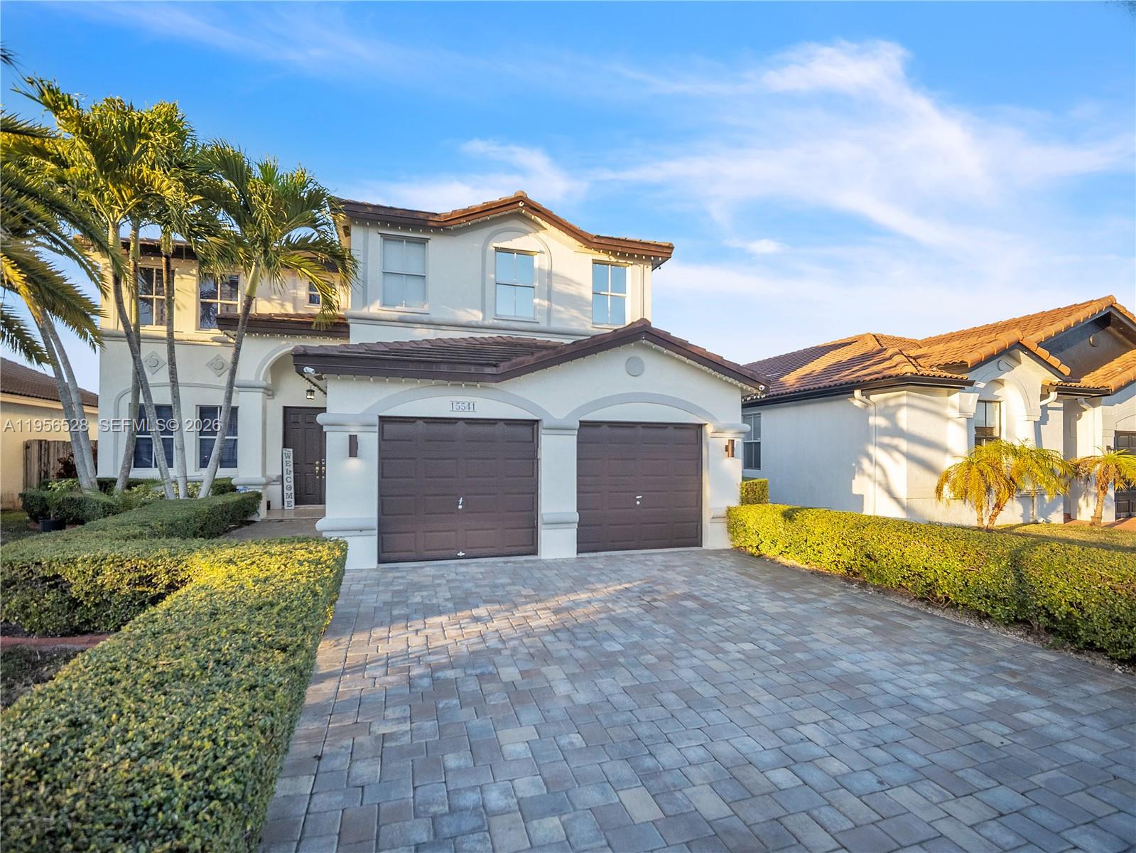 15541 Southwest 21st Terrace Miami, FL 33185 - Photo 1 of 34 a front view of a house with a yard and garage