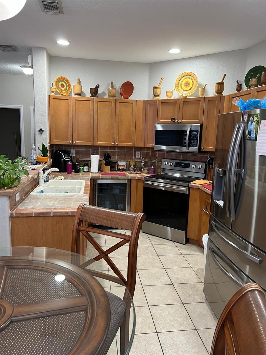 15541 Southwest 21st Terrace Miami, FL 33185 - Photo 12 of 21 a kitchen with stainless steel appliances granite countertop a stove a sink and a refrigerator