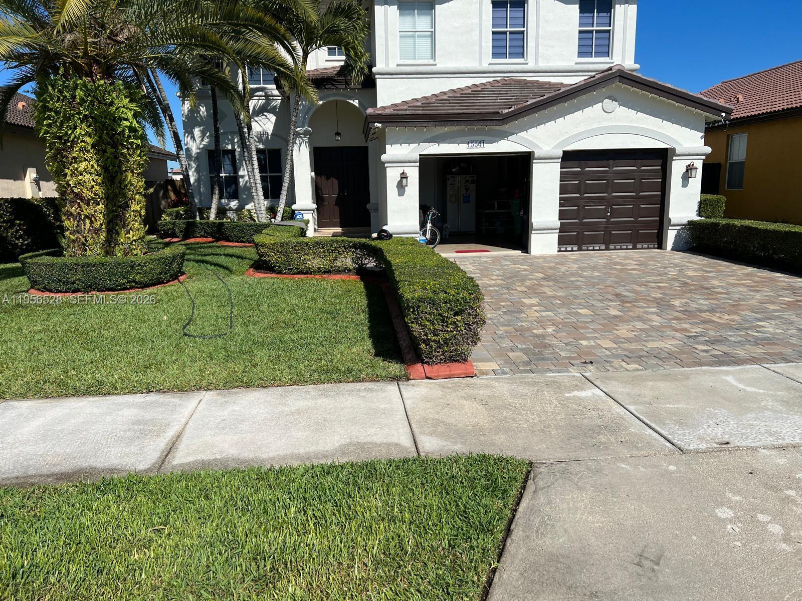 15541 Southwest 21st Terrace Miami, FL 33185 - Photo 3 of 21 a front view of a house with a yard and garage