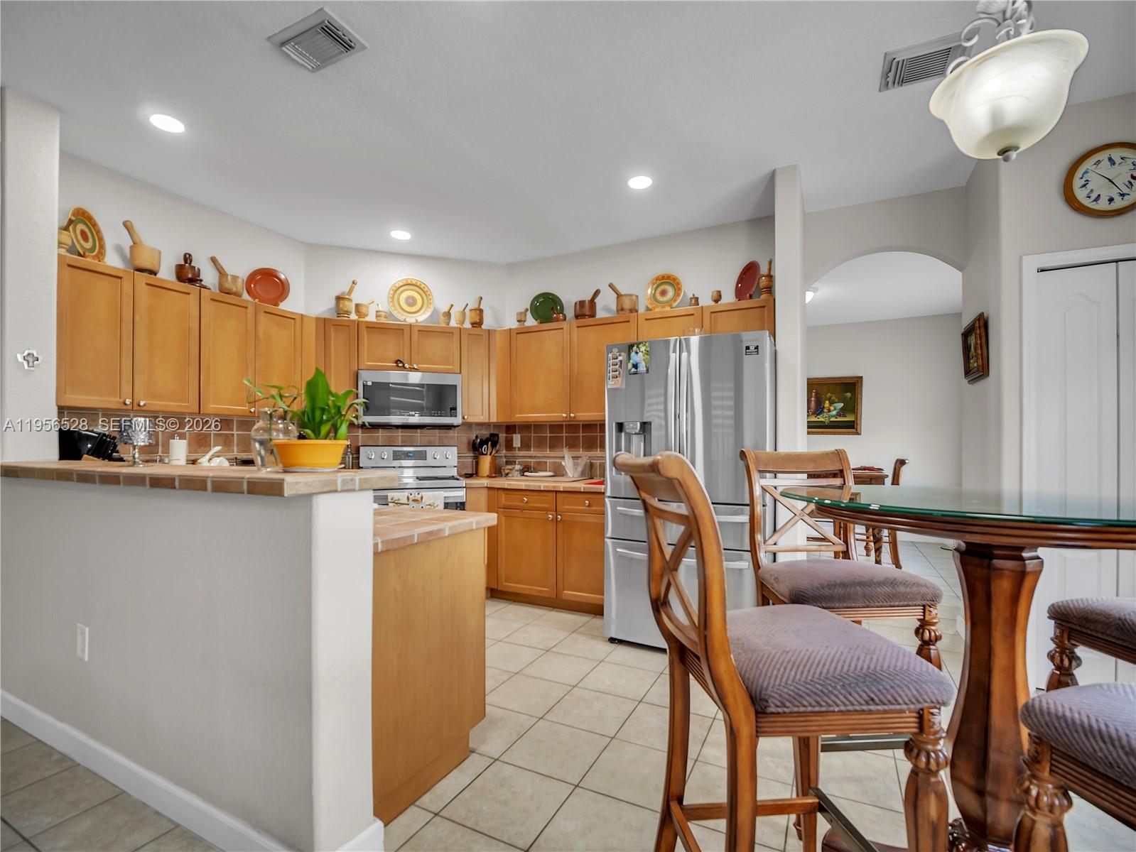 15541 Southwest 21st Terrace Miami, FL 33185 - Photo 6 of 34 a kitchen with stainless steel appliances granite countertop a table and chairs in it