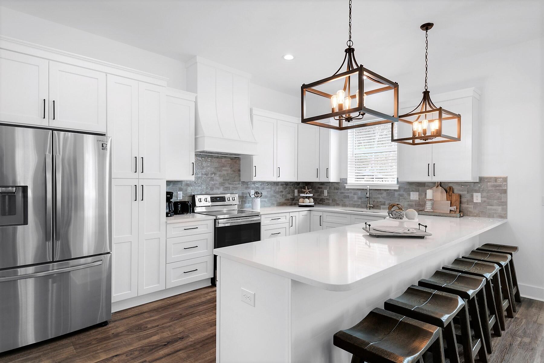 4458 Luke Avenue Destin, FL 32541 - Photo 15 of 41 a kitchen with white cabinets and stainless steel appliances