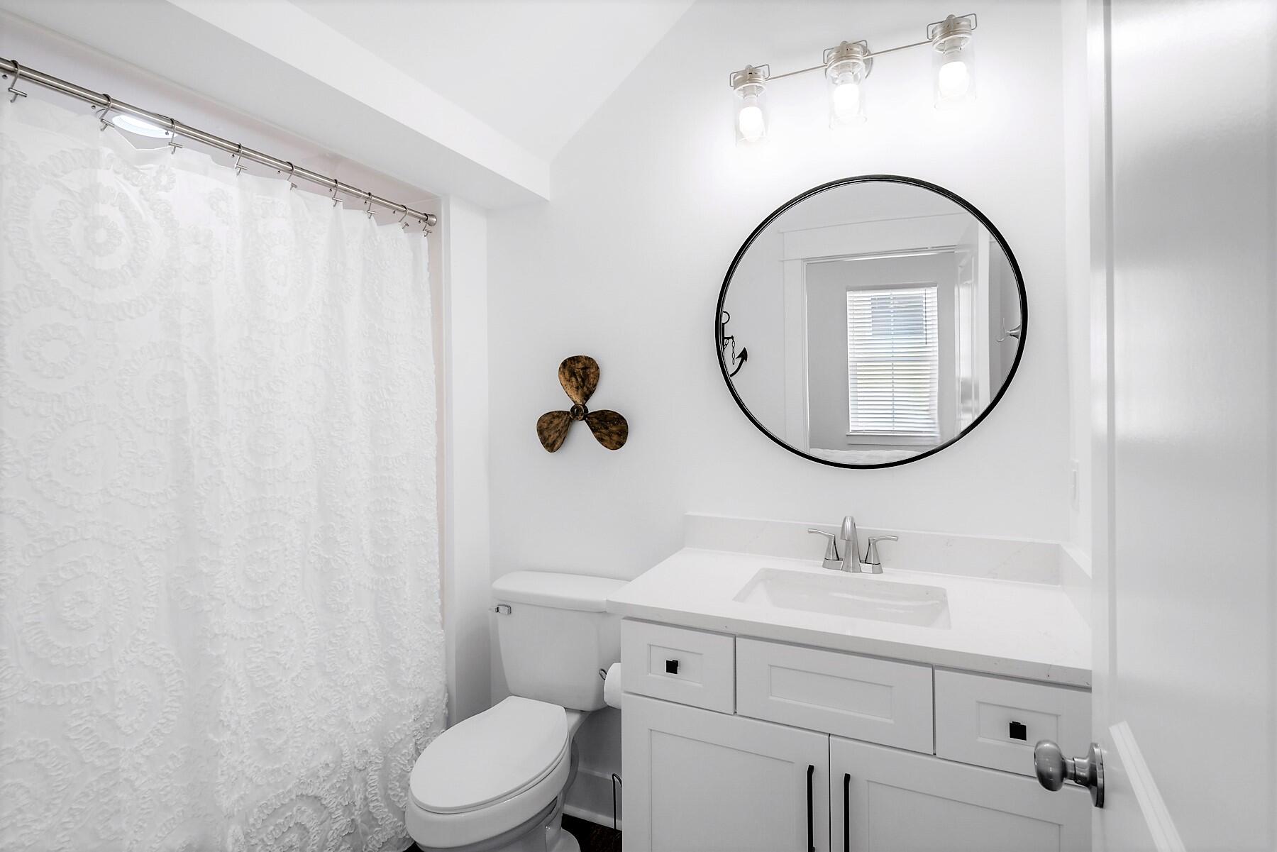 4458 Luke Avenue Destin, FL 32541 - Photo 23 of 41 a bathroom with a sink a mirror a toilet and a shower