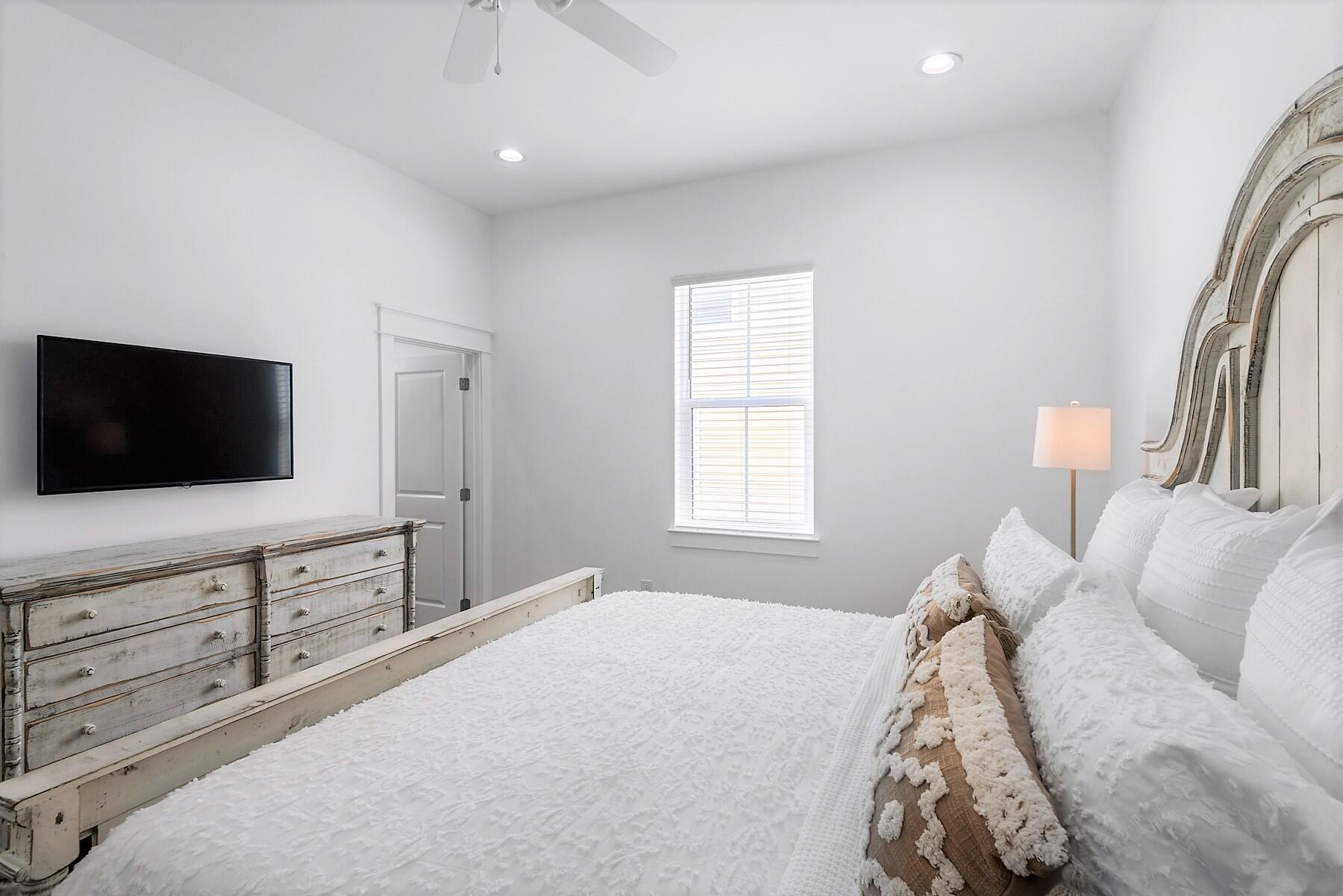 4458 Luke Avenue Destin, FL 32541 - Photo 26 of 41 a bedroom with a large bed and a flat screen tv