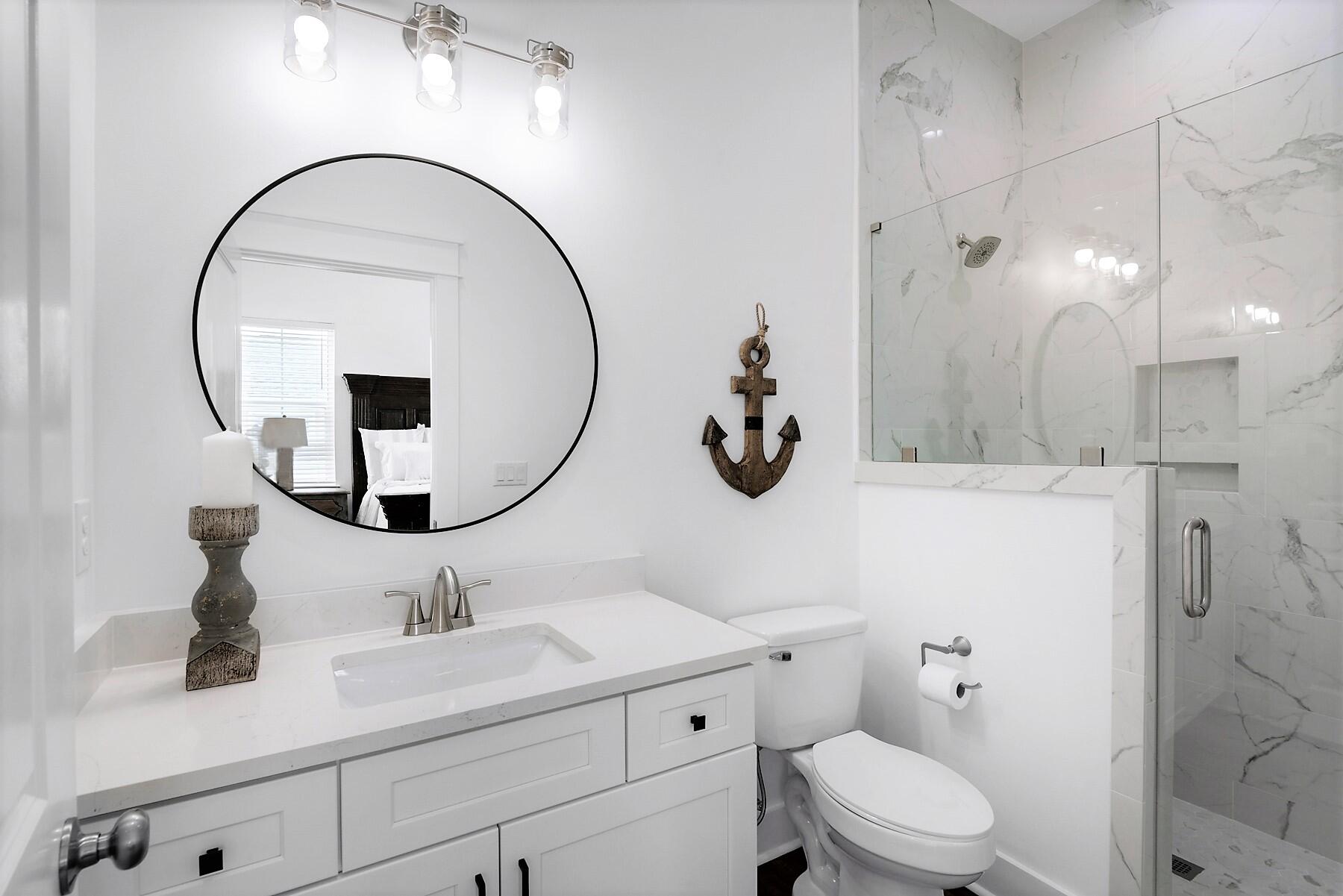 4458 Luke Avenue Destin, FL 32541 - Photo 30 of 41 a bathroom with a toilet sink and mirror