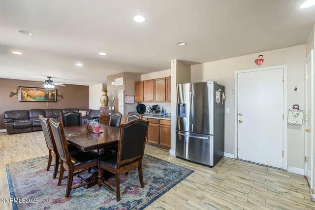 a kitchen with stainless steel appliances kitchen island granite countertop a refrigerator a stove a sink dishwasher with a dining table and chairs