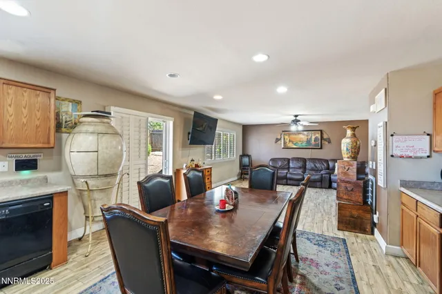 a kitchen with stainless steel appliances granite countertop a table chairs sink and cabinets