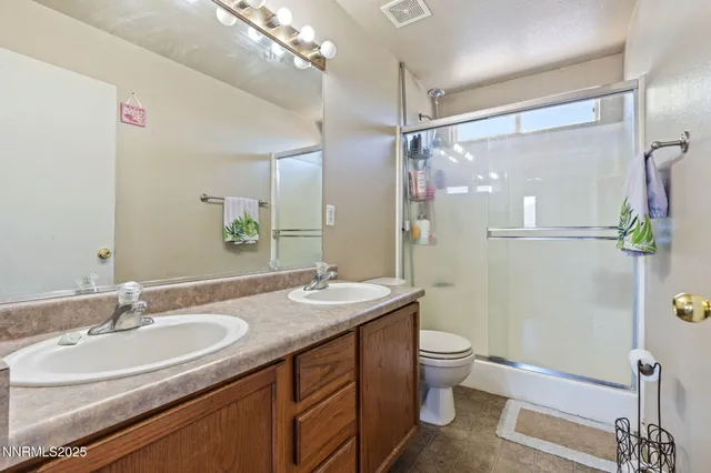 a bedroom with a bed a dresser and potted plant