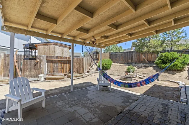 a view of a patio with a table and chairs under an umbrella