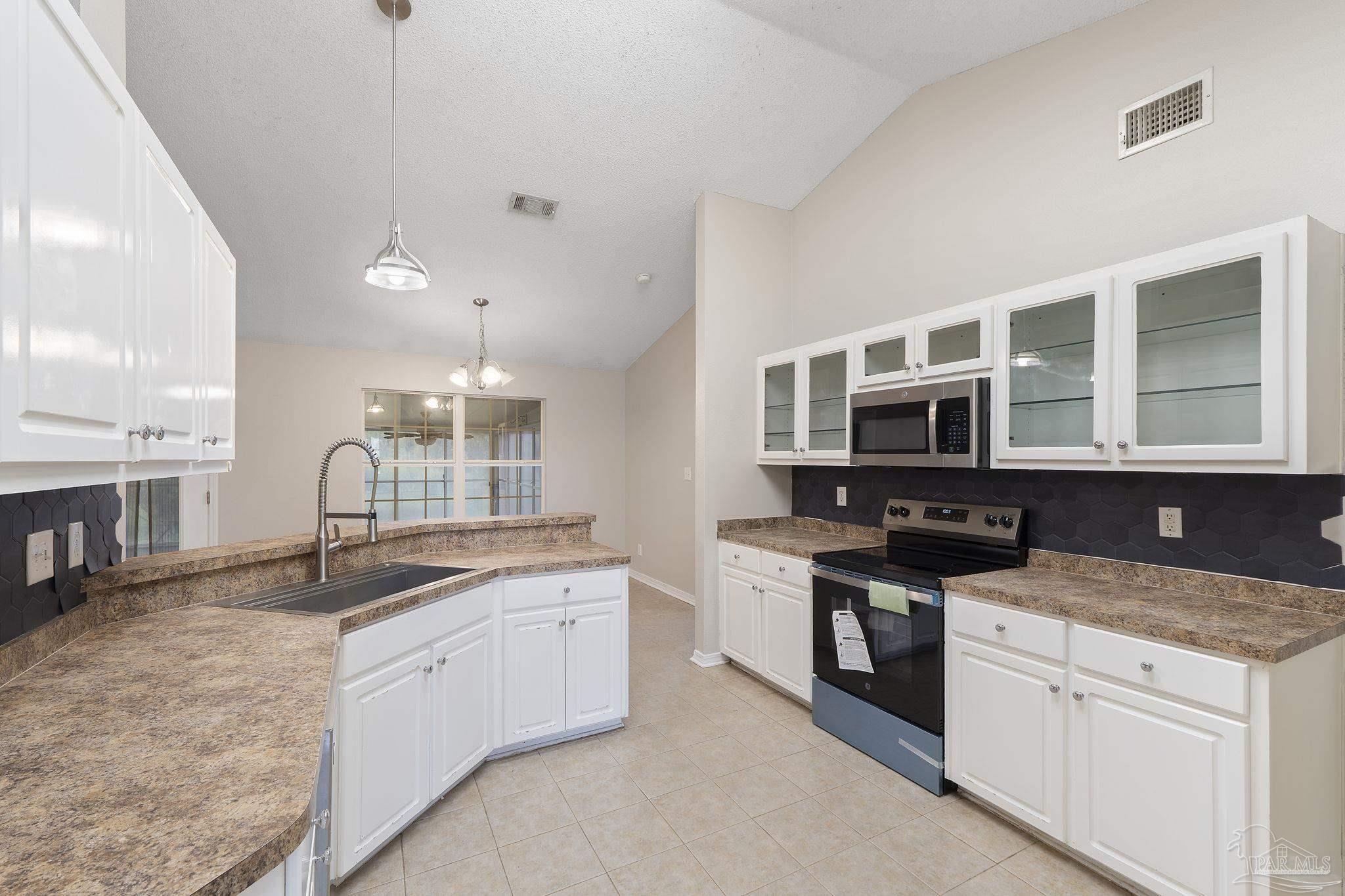 5642 Berrybrook Circle Pace, FL 32571 - Photo 14 of 72 a kitchen with stainless steel appliances granite countertop a sink stove and cabinets