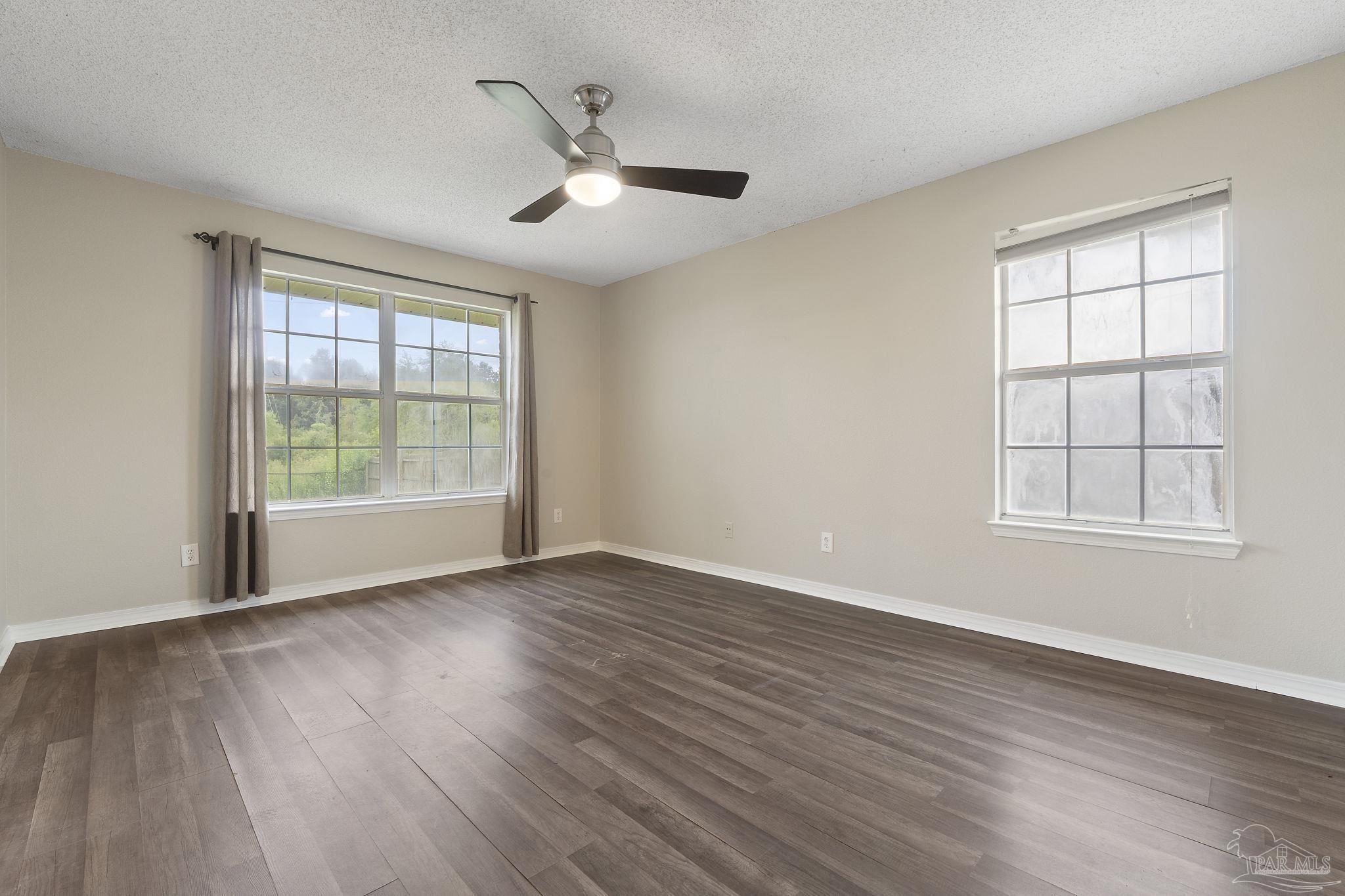 5642 Berrybrook Circle Pace, FL 32571 - Photo 16 of 72 a view of an empty room with wooden floor and a window