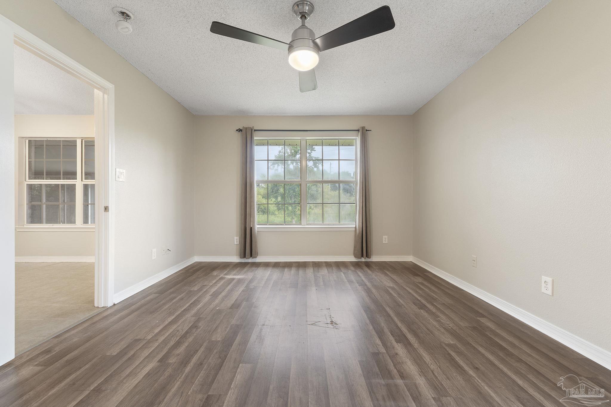 5642 Berrybrook Circle Pace, FL 32571 - Photo 17 of 72 an empty room with wooden floor ceiling fan and windows