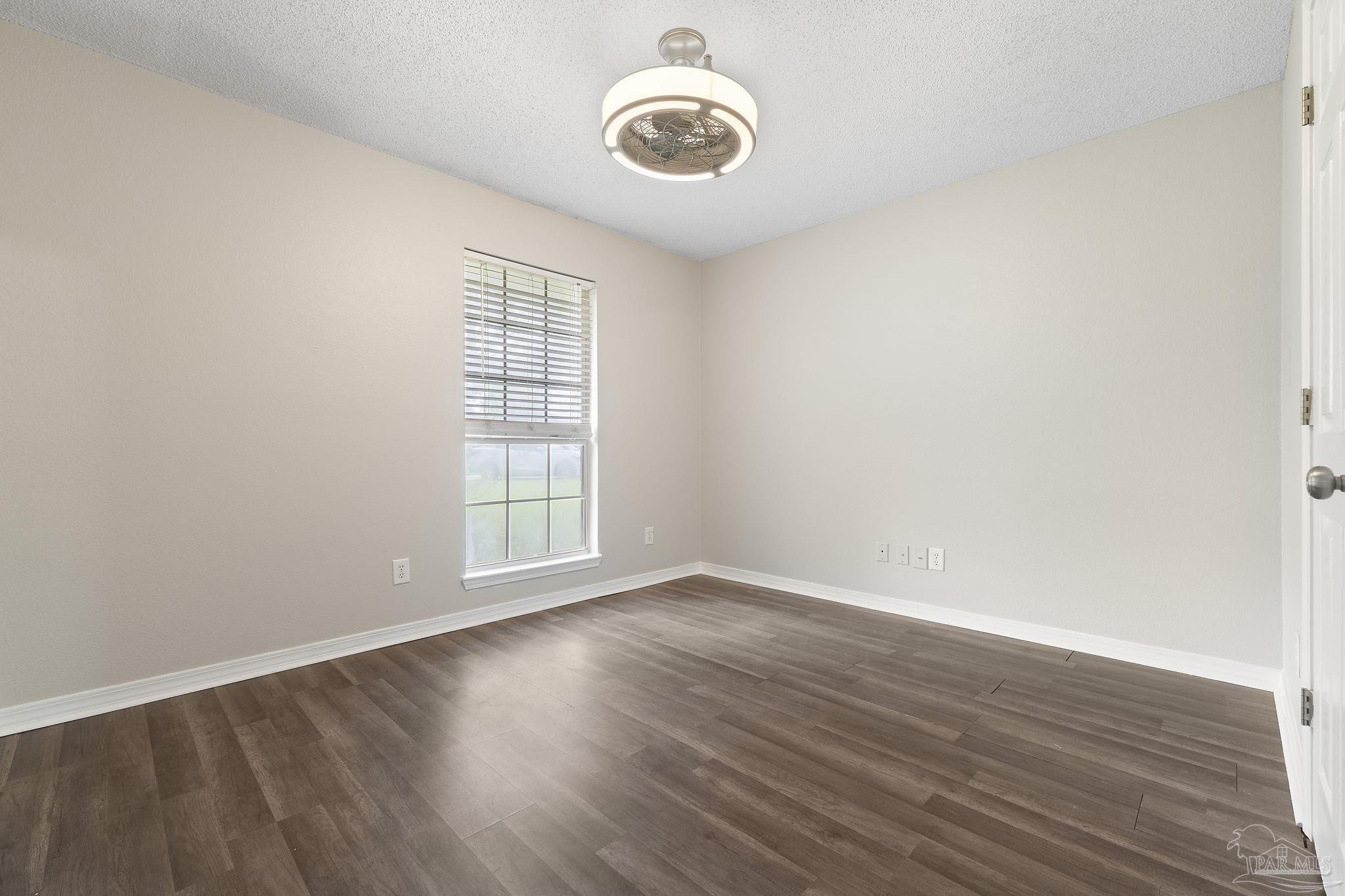 5642 Berrybrook Circle Pace, FL 32571 - Photo 23 of 72 a view of an empty room with wooden floor and a window