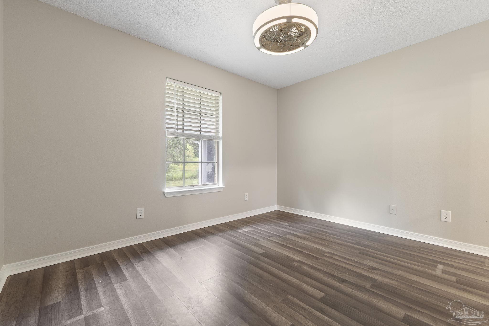 5642 Berrybrook Circle Pace, FL 32571 - Photo 27 of 72 a view of an empty room with wooden floor and a window