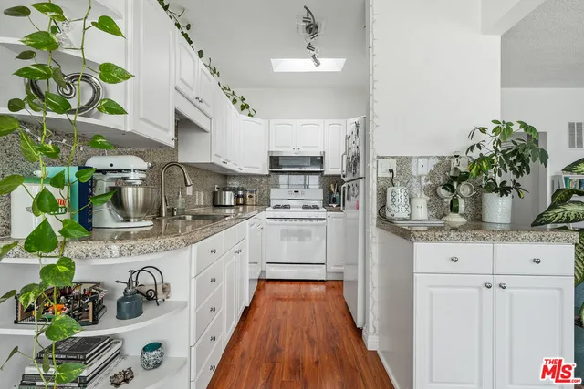 a kitchen with stainless steel appliances granite countertop a white cabinets stove and sink