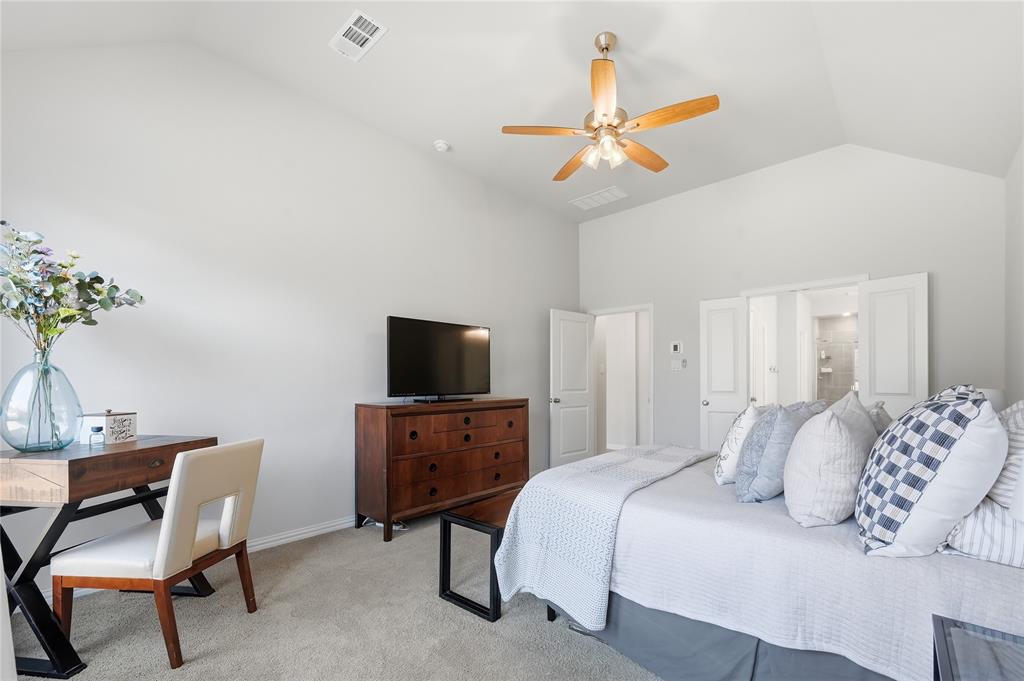 9317 Sunset Lane Oak Point, TX 75068 - Photo 14 of 40 a bedroom with a bed and a chandelier