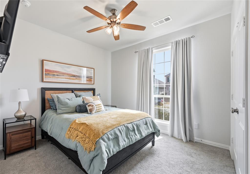 9317 Sunset Lane Oak Point, TX 75068 - Photo 19 of 40 a bedroom with a large bed and a chandelier