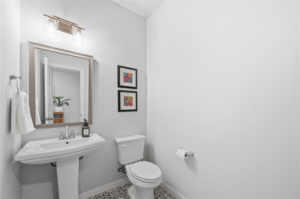 9317 Sunset Lane Oak Point, TX 75068 - Photo 23 of 40 a bathroom with a toilet a sink and mirror