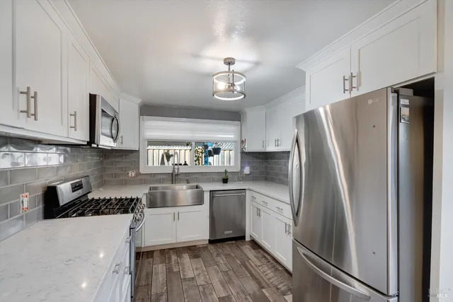 a kitchen with stainless steel appliances a refrigerator sink and cabinets