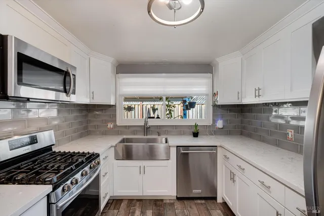 a kitchen with white cabinets and appliances