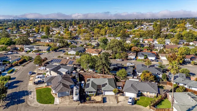 an aerial view of residential houses with outdoor space and trees