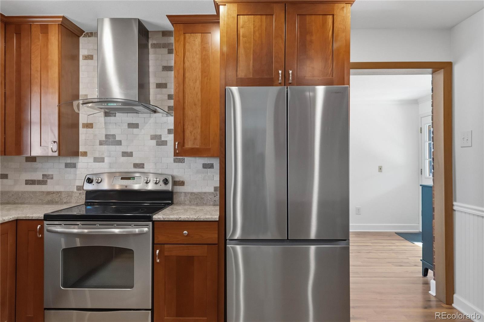 6984 Dover Way Arvada, CO 80004 - Photo 11 of 39 a kitchen with appliances a refrigerator and cabinets