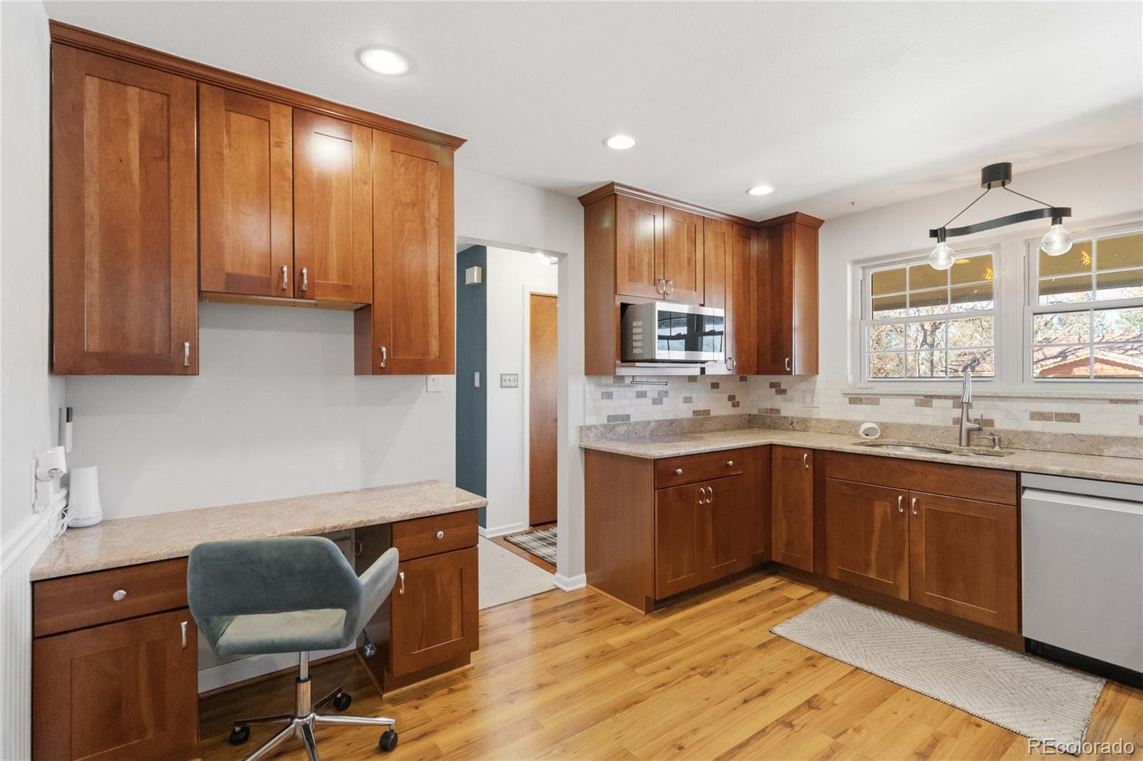 6984 Dover Way Arvada, CO 80004 - Photo 12 of 39 a kitchen with kitchen island granite countertop wooden cabinets a sink and dishwasher