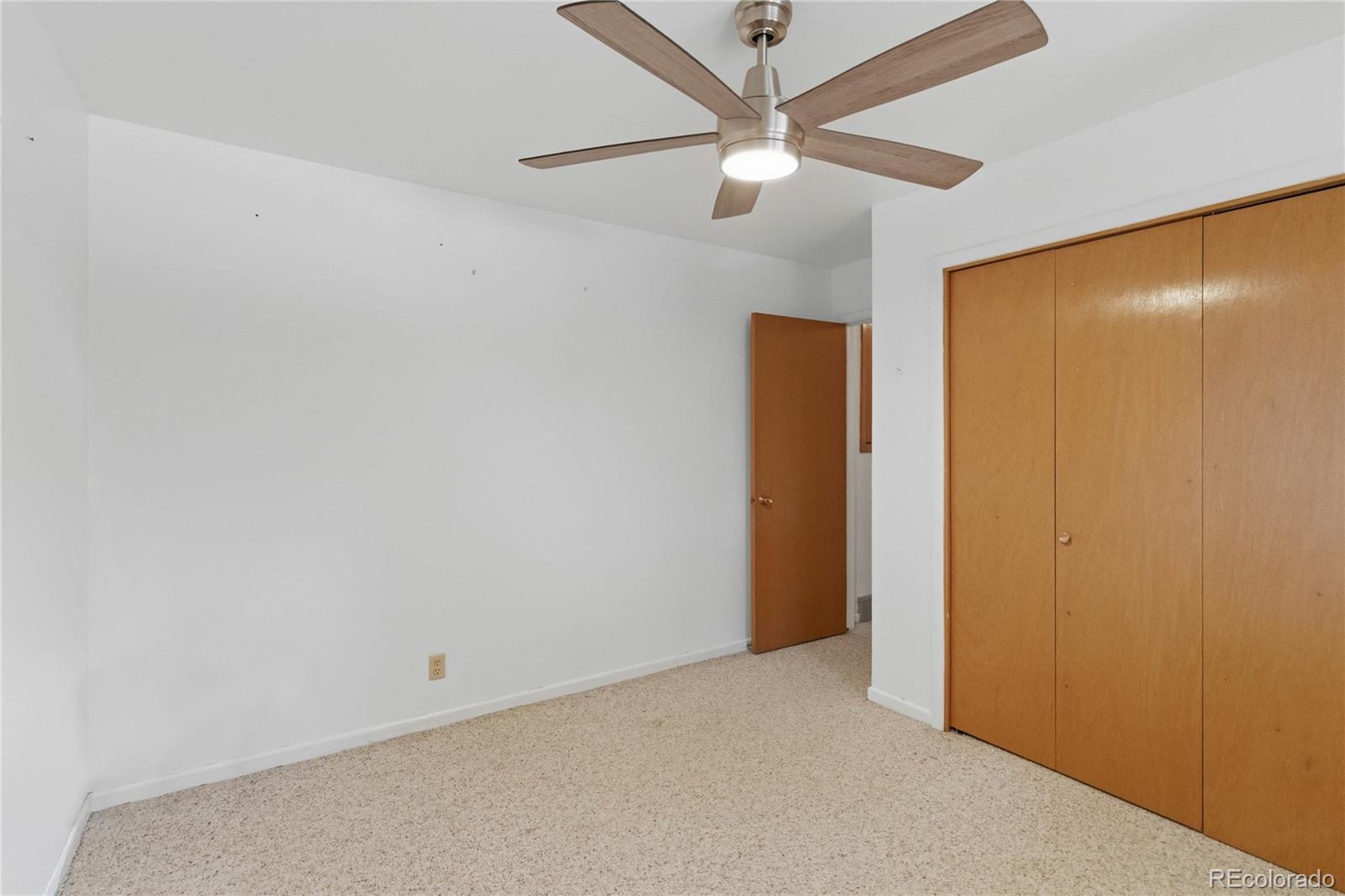 6984 Dover Way Arvada, CO 80004 - Photo 23 of 39 an empty room with a fan & a ceiling fan