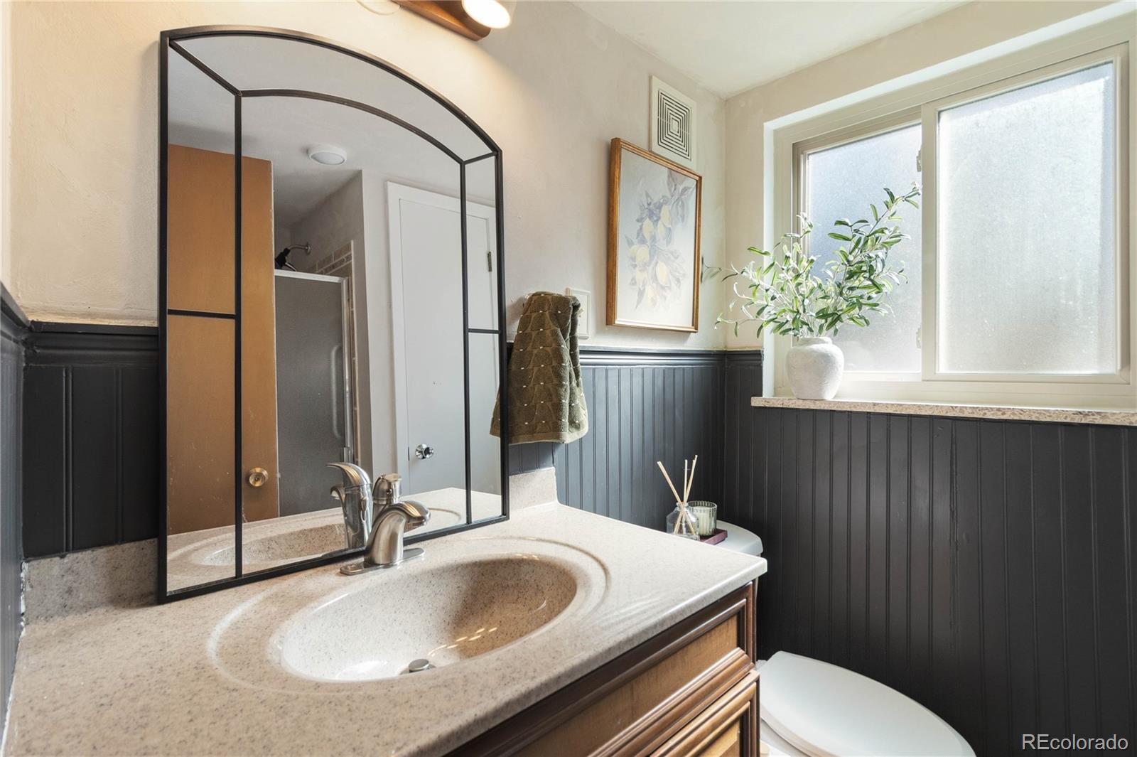 6984 Dover Way Arvada, CO 80004 - Photo 29 of 39 a bathroom with a granite countertop sink and a mirror