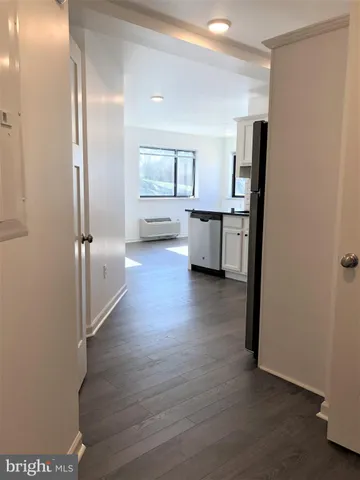a view of a kitchen with refrigerator and wooden floor