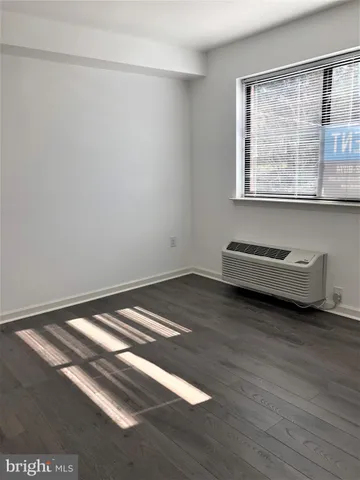 a view of a room with wooden floor and a window
