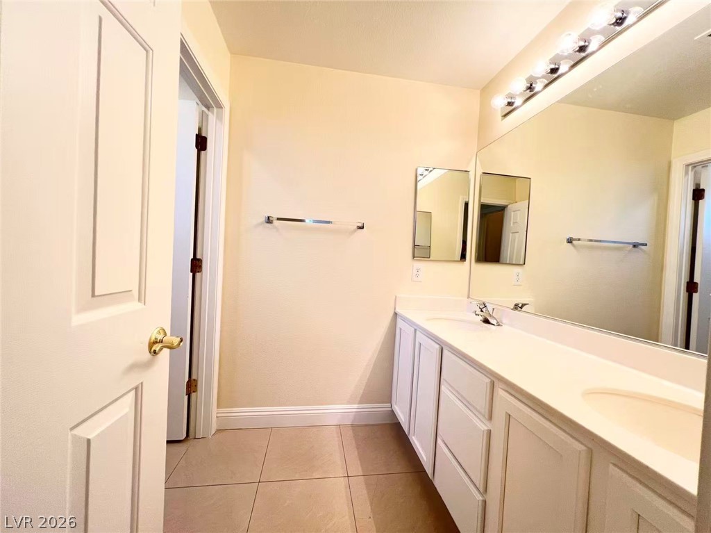 9891 Ridge Hill Avenue Las Vegas, NV 89147 - Photo 27 of 29 A pristine bathroom features a dual vanity with a wide mirror, perfectly illuminated for your daily routine.