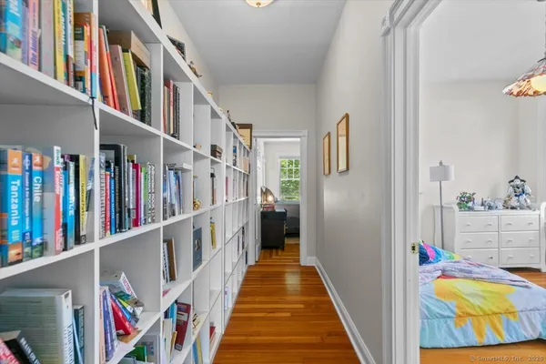 a view of a hallway with lots of frames on wall