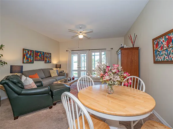 a living room with furniture flowerpot and a chandelier