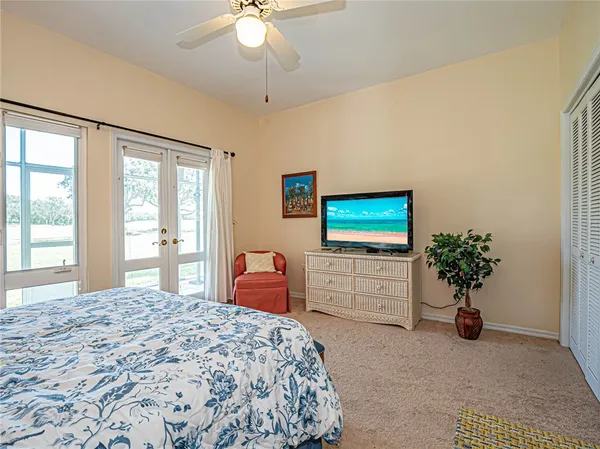 a bedroom with furniture a flat screen tv and a chandelier