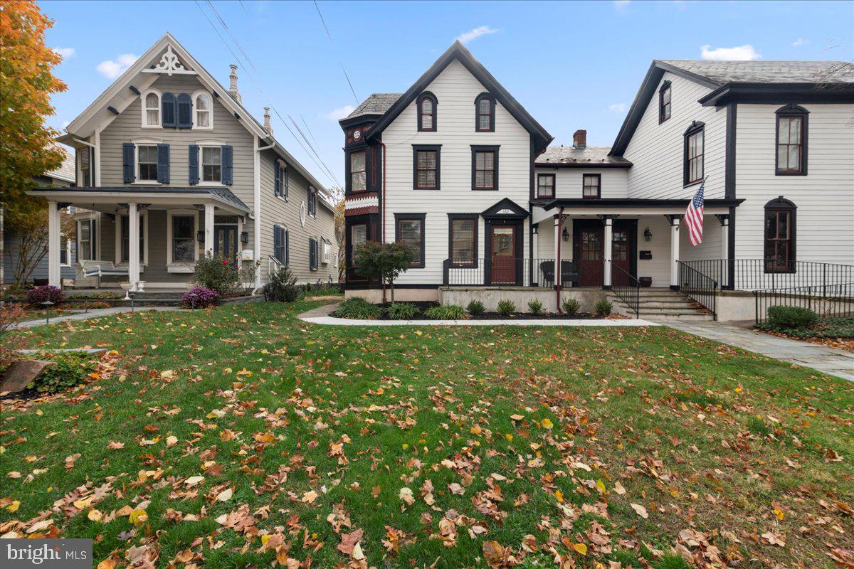 a front view of residential houses with yard and green space
