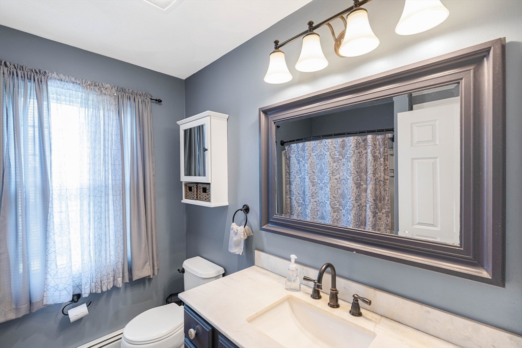 54 Old Merrill Street Amesbury, MA 01913 - Photo 22 of 34 a bathroom with a toilet a sink a mirror and a window