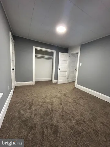 an empty room with closet and natural light