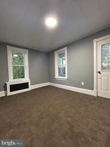 an empty room with windows and closet
